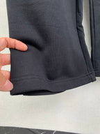 Balenciaga pants cuff hem with visible stitching on dark fabric