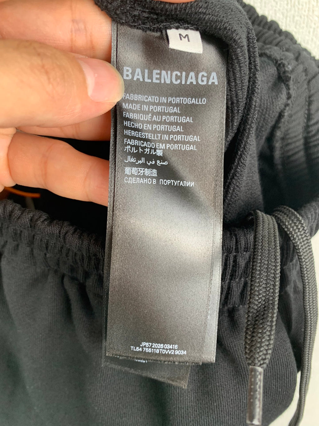 Black pants size M tag with Balenciaga branding and made in Portugal info