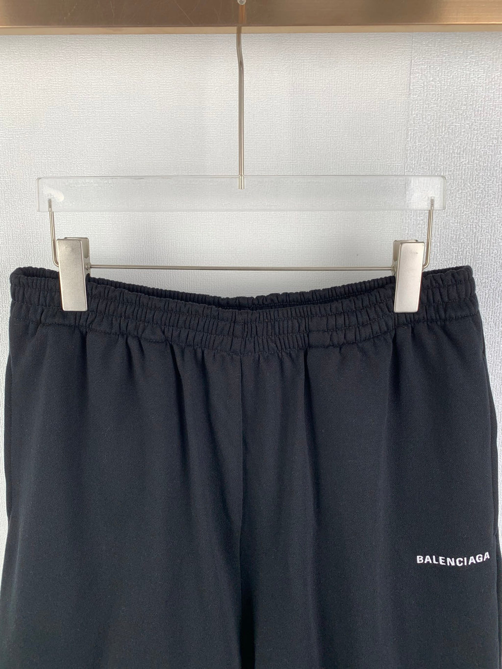 Dark knit shorts on hangers, elastic waistband and side logo patch