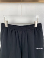 Dark knit shorts on hangers, elastic waistband and side logo patch