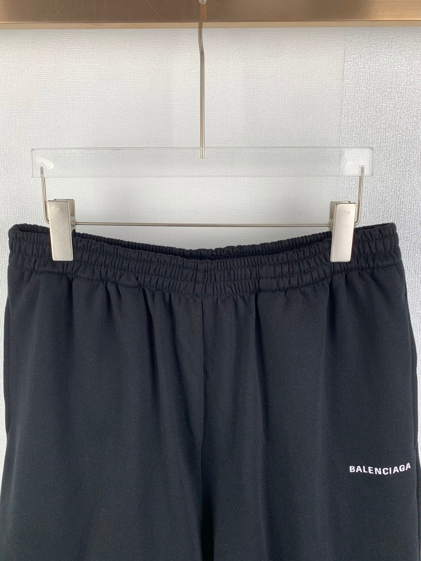 Dark knit shorts on hangers, elastic waistband and side logo patch