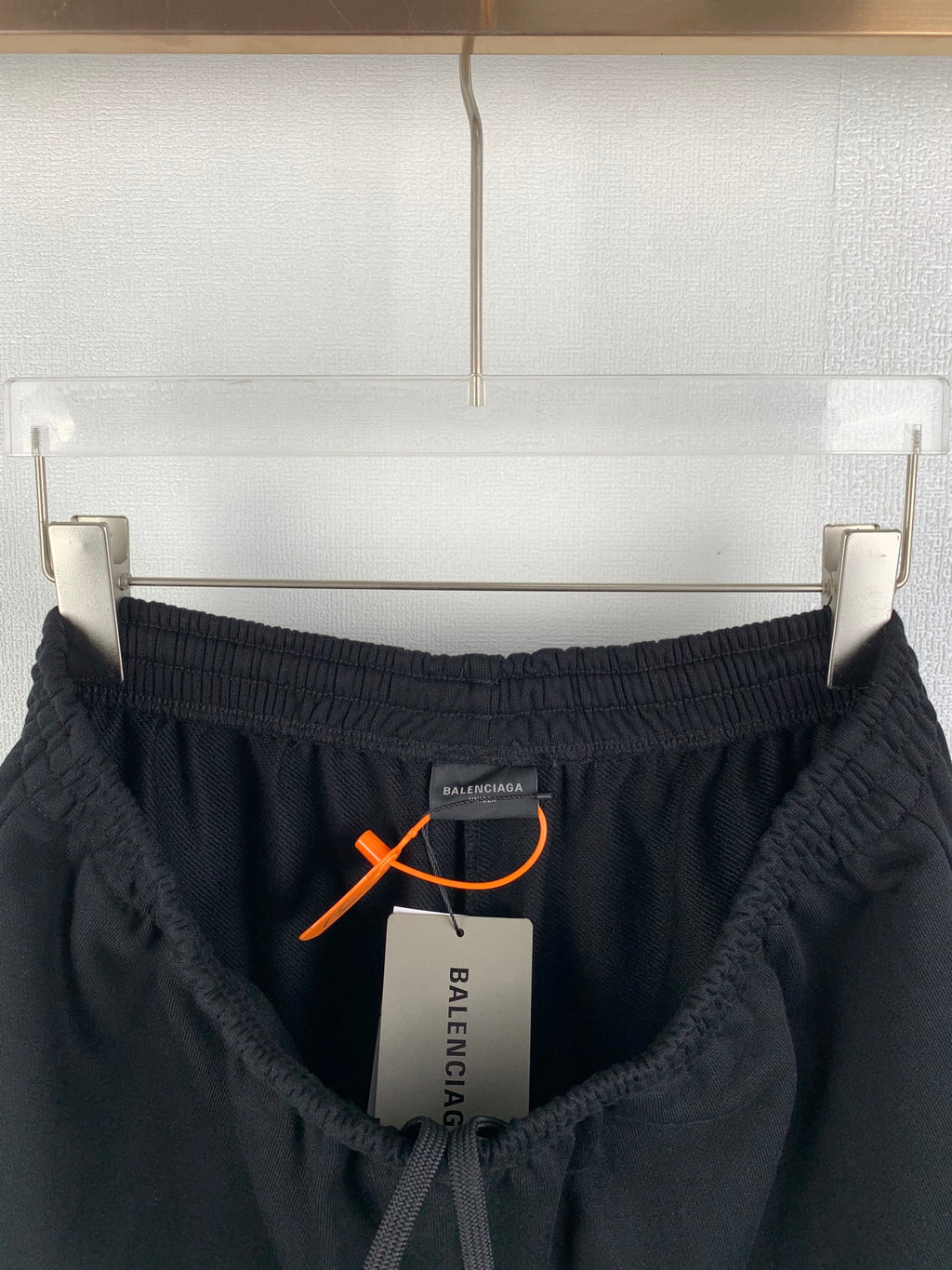 Black Balenciaga pants with elastic waistband and orange drawstring toggle