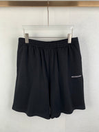 Dark knit shorts with elastic waistband and draped front folds