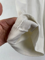 White shorts folded at the cuff, showing woven fabric texture