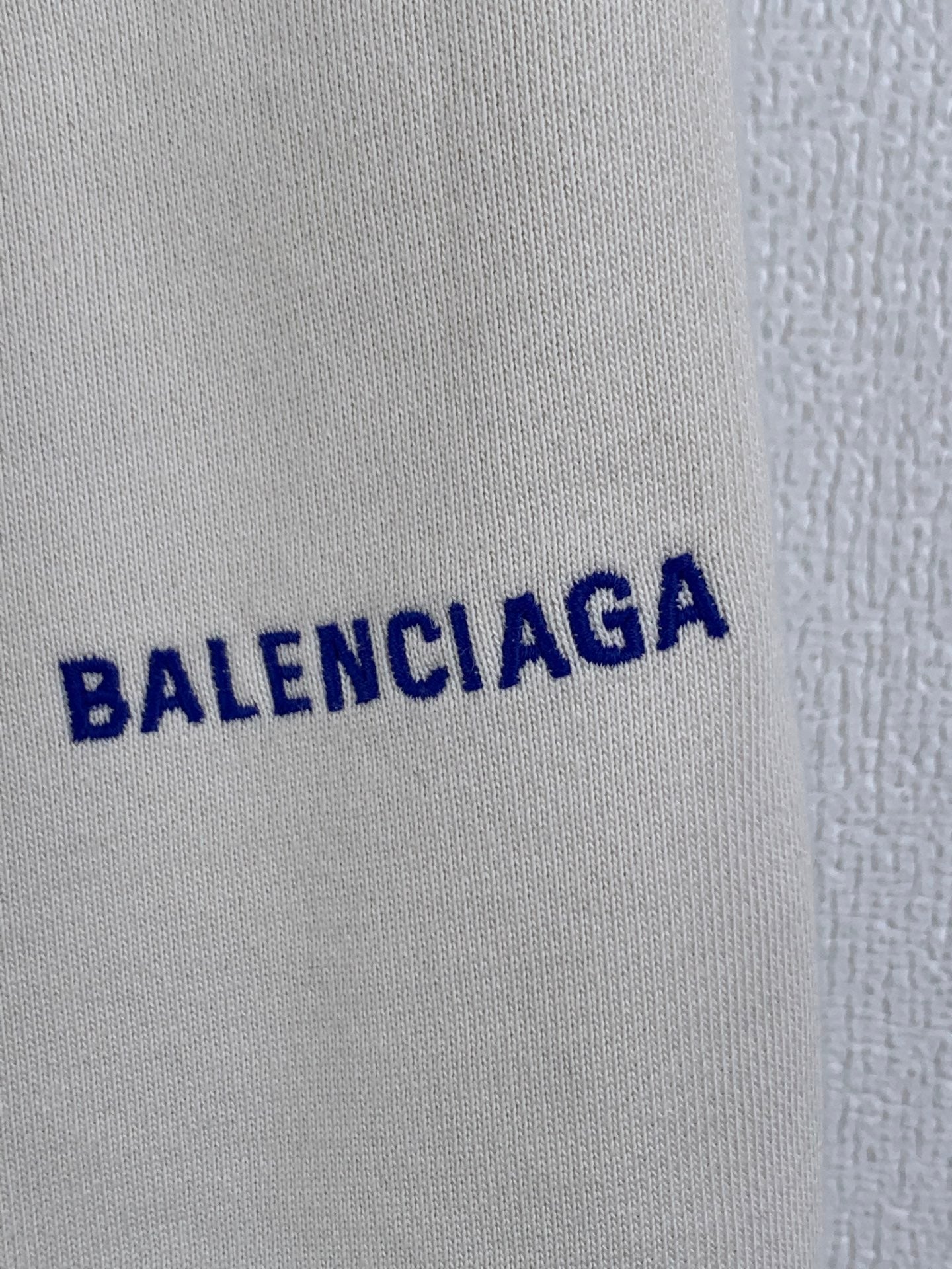 White shorts with close-up view of the blue BALENCIAGA logo