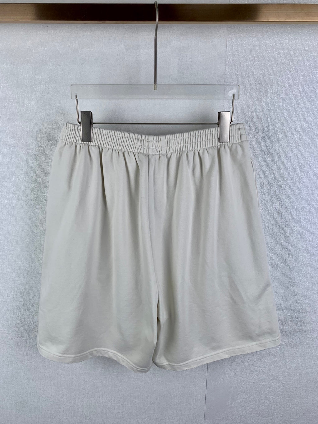 White elastic-waist shorts with pleated front and relaxed drape