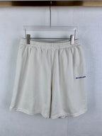 White elastic-waist shorts with pleated front and blue BALENCIAGA logo on side