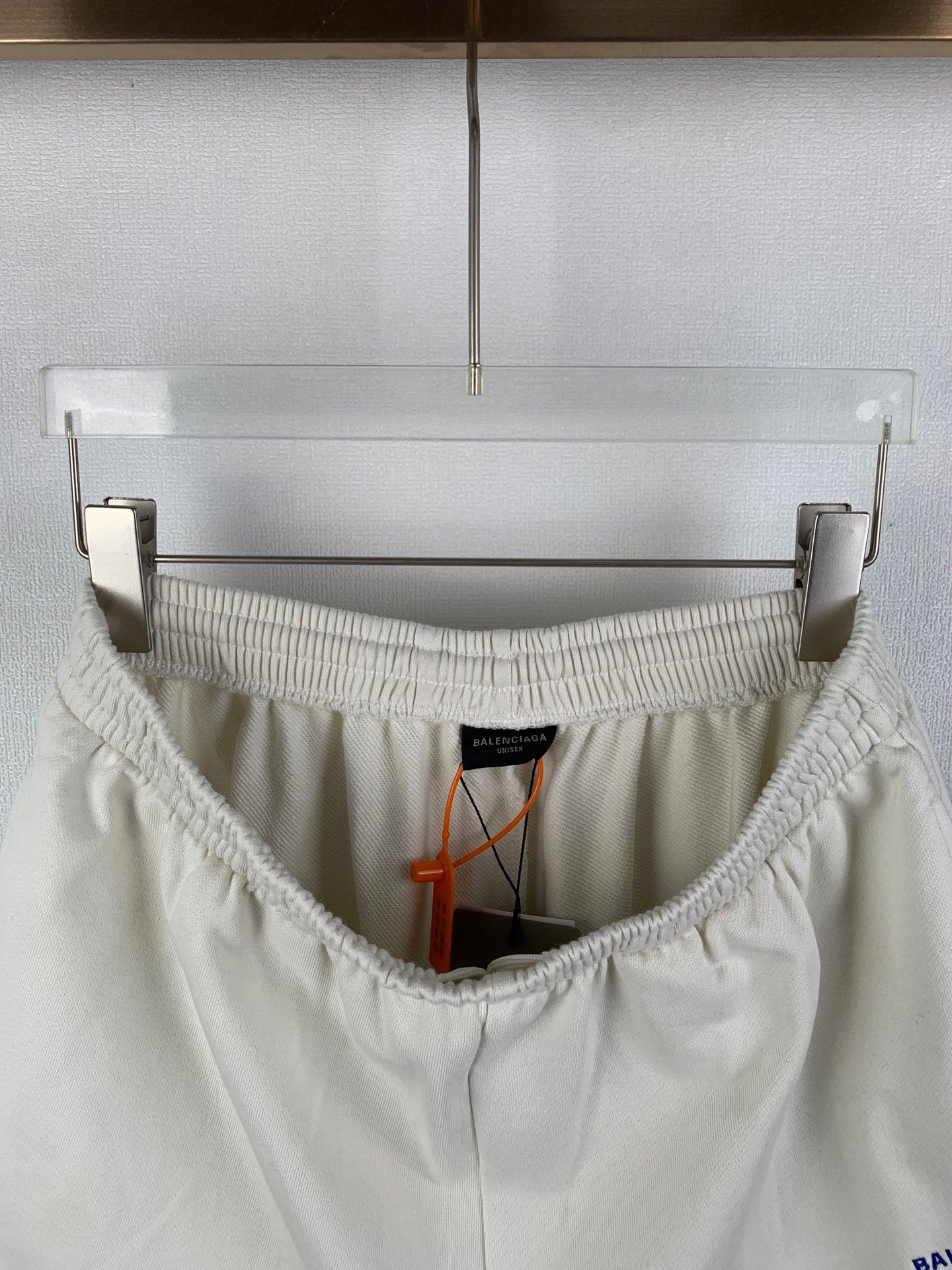 White shorts interior with elastic waistband, black label, and orange drawstring
