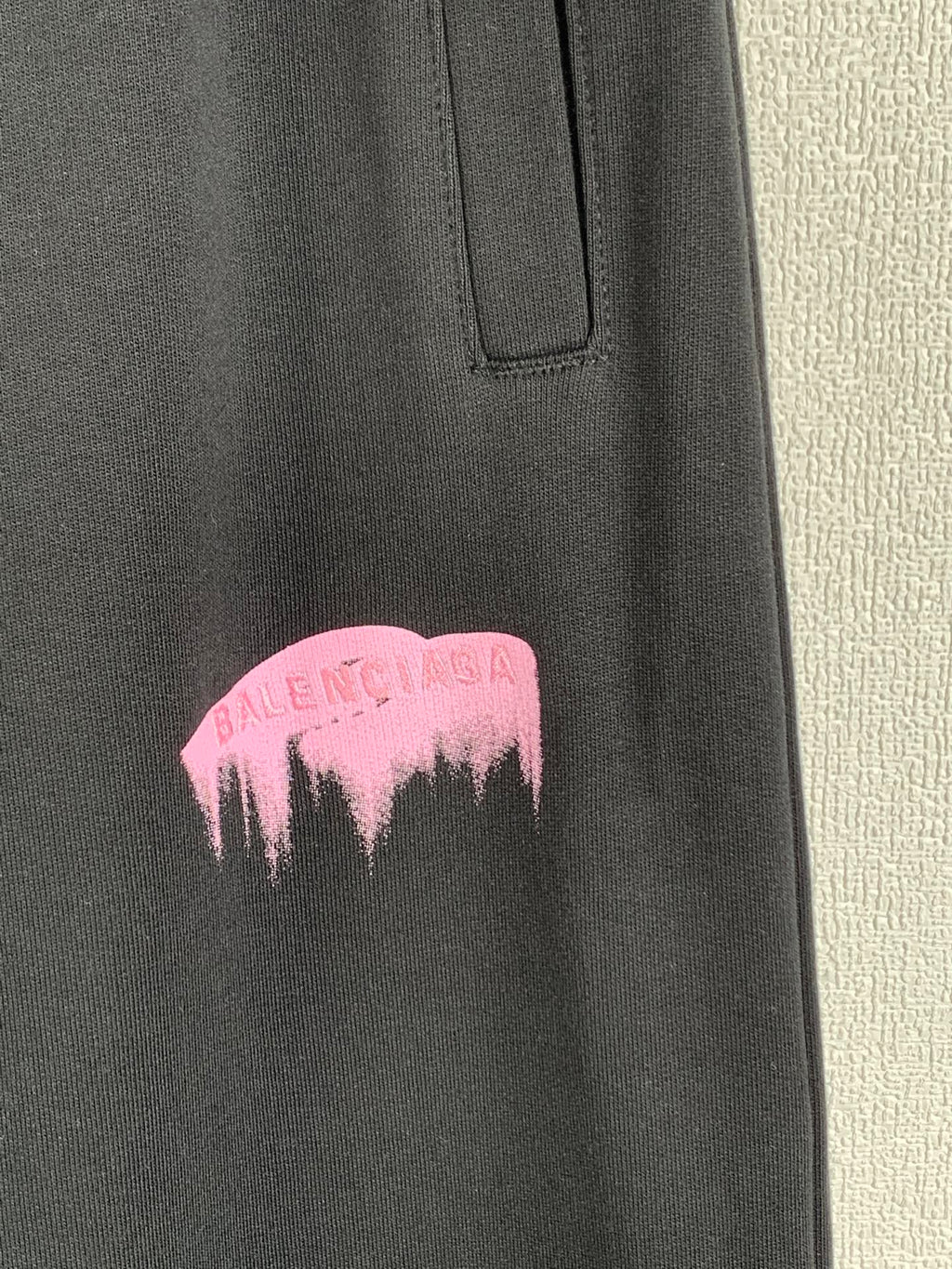 Balenciaga dark pants with pink dripping logo at thigh