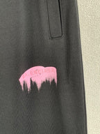Balenciaga dark pants with pink dripping logo at thigh