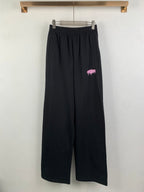 Balenciaga black wide-leg pants with elastic waistband and pink logo print