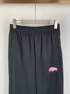 Balenciaga black pants front view with elastic waistband, side pockets, pink logo