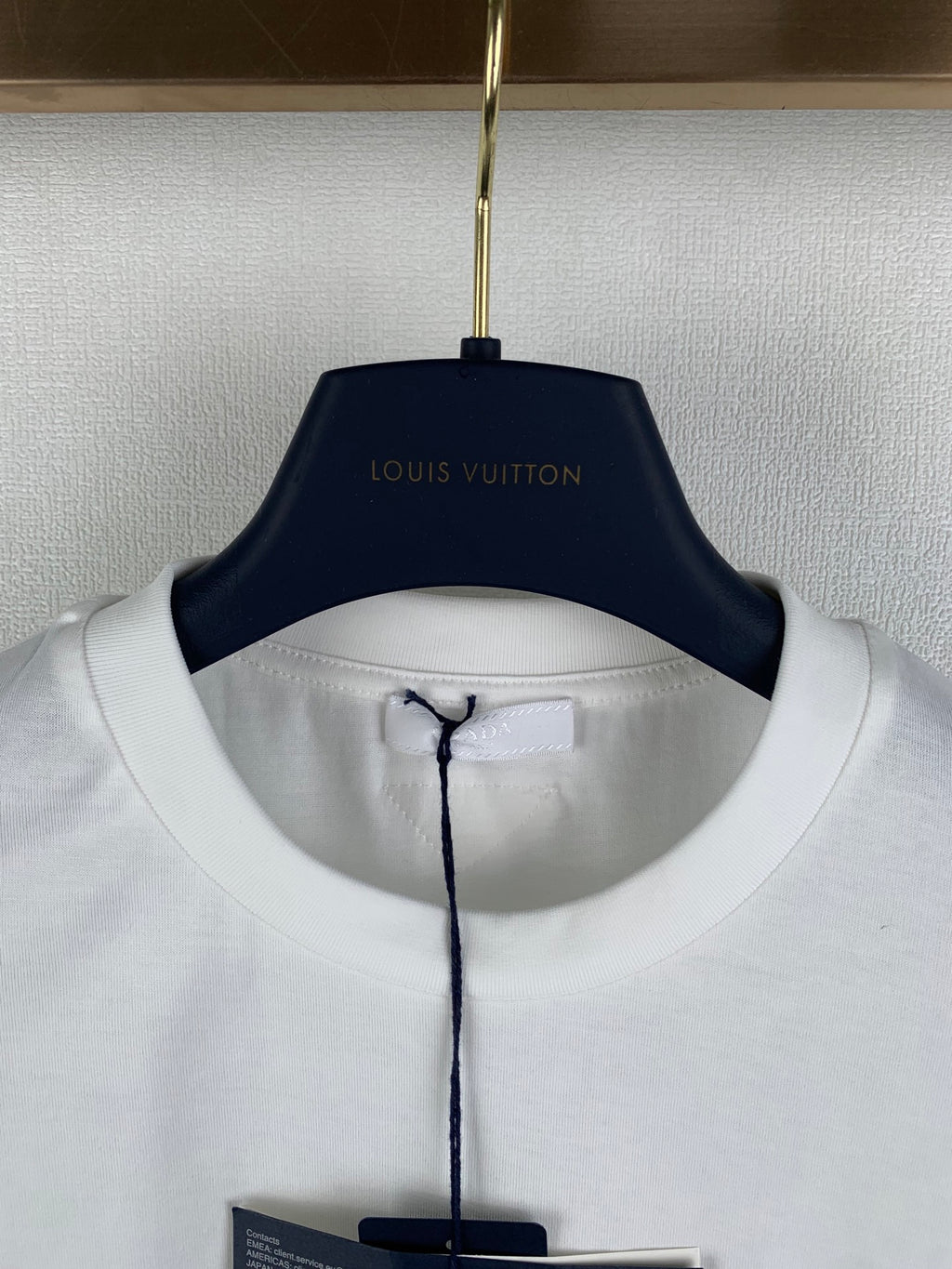 White crewneck T-shirt collar with black hang tag beneath
