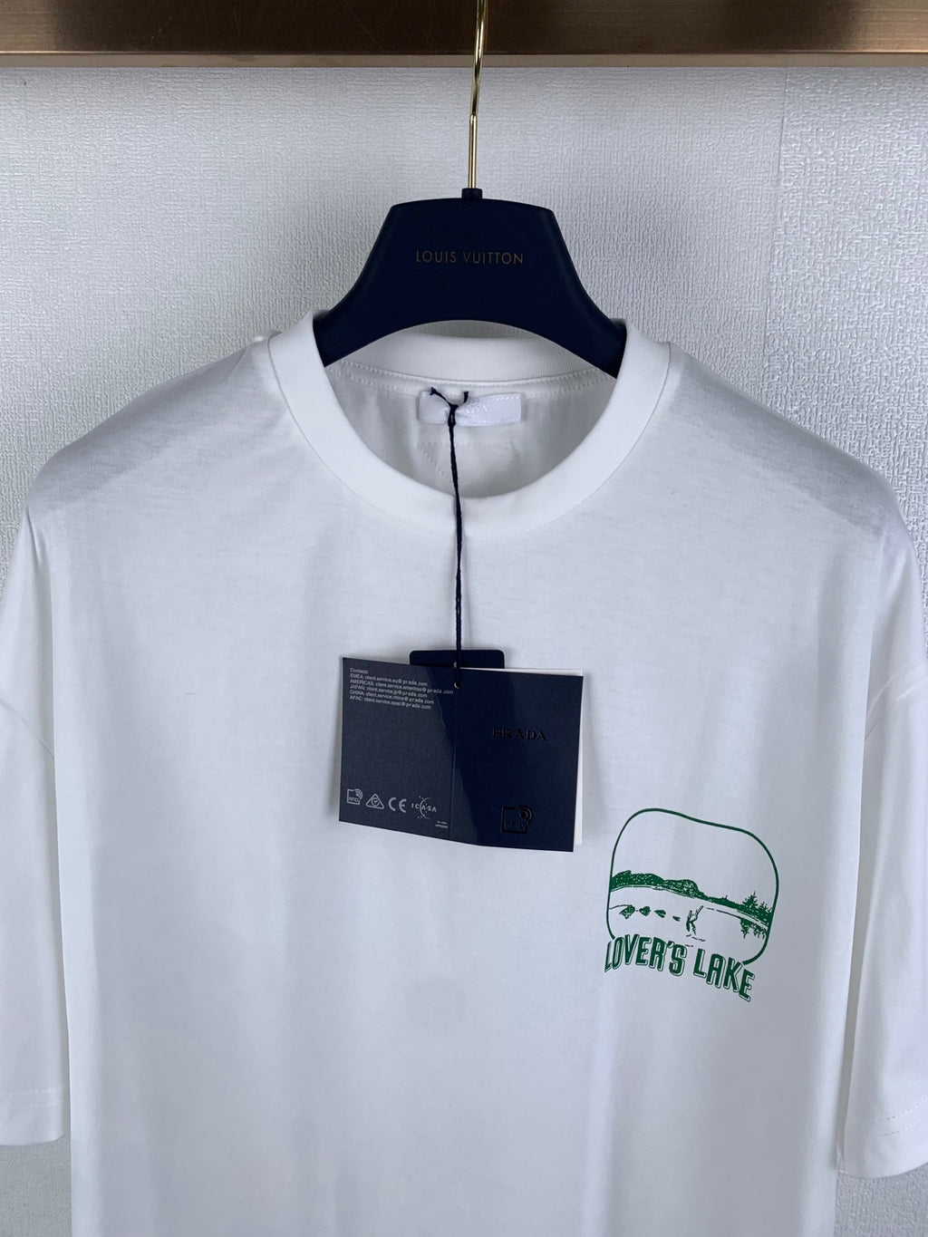 White crewneck T-shirt with green "LOVER'S LAKE" logo print, front close-up