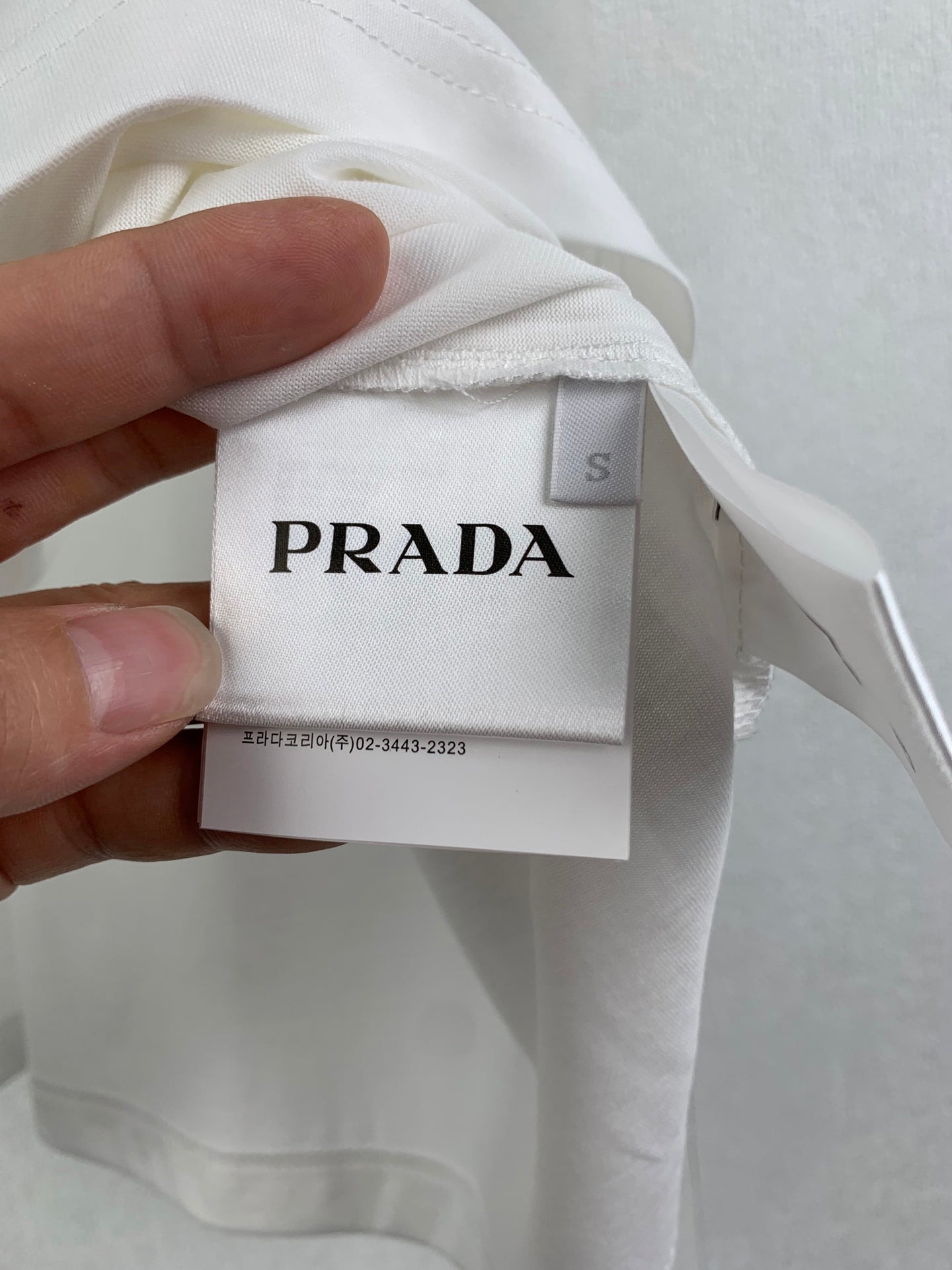 White T-shirt with PRADA label tag at neckline
