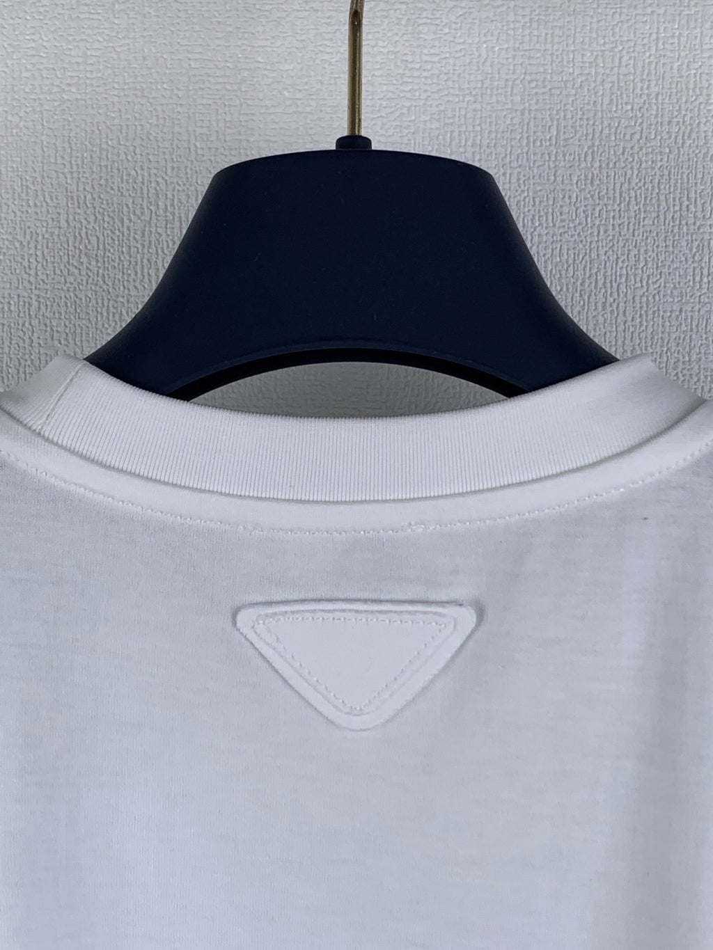 Prada short-sleeve top with ribbed crew neckline and triangular logo patch.