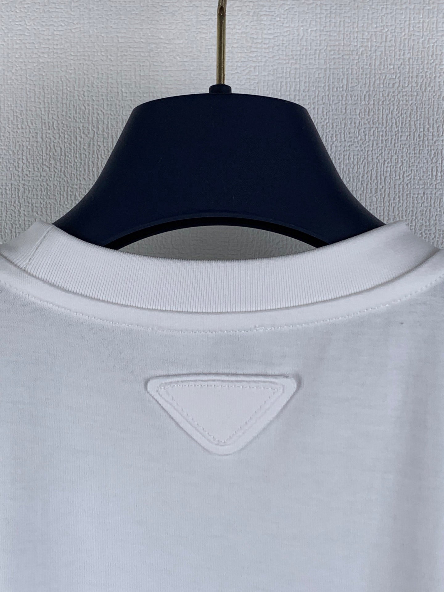 Prada short-sleeve top with ribbed crew neckline and triangular logo patch.