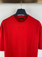 Red crew-neck T-shirt close-up, triangular chest logo, Louis Vuitton on hanger.