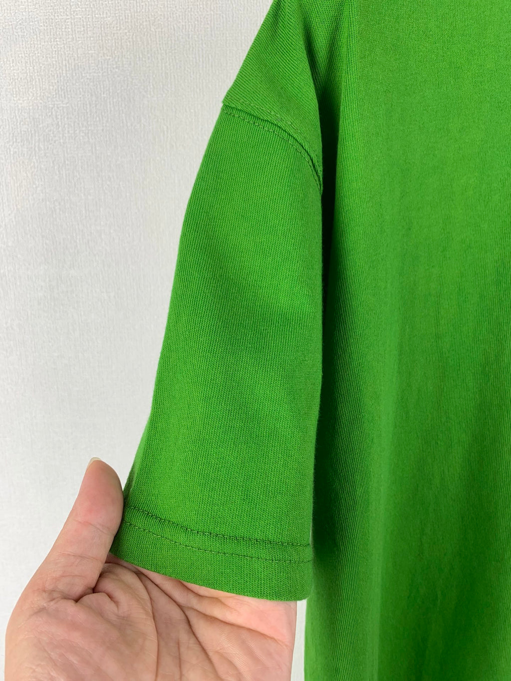 Prada short-sleeve T-shirt in bright green, side view with sleeve hem stitching