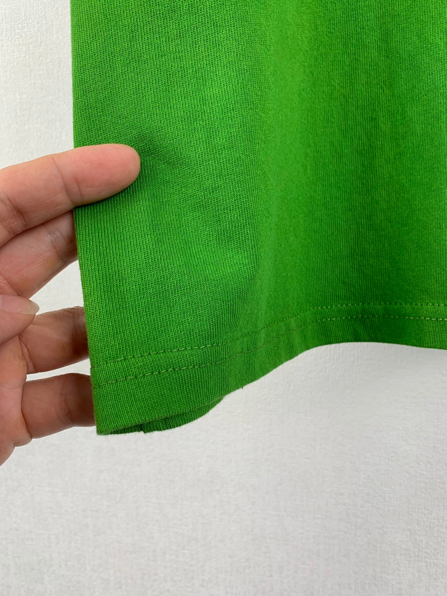 Prada short-sleeve T-shirt in bright green, close-up of stitched hem edge