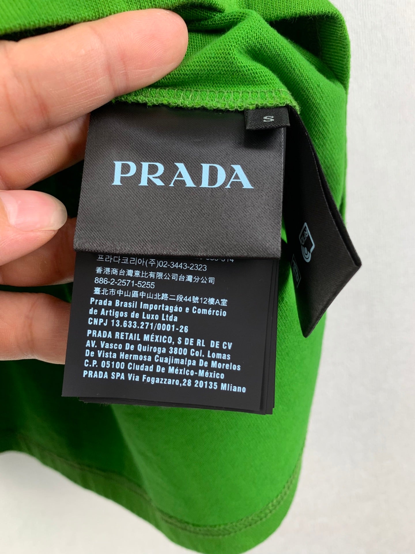 Prada care label tag on bright green short-sleeve T-shirt