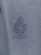 Embroidered Prada logo crest on navy T-shirt fabric