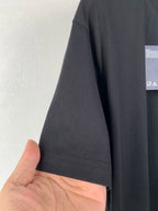 Prada T-shirt sleeve and hem in dark fabric with visible stitching