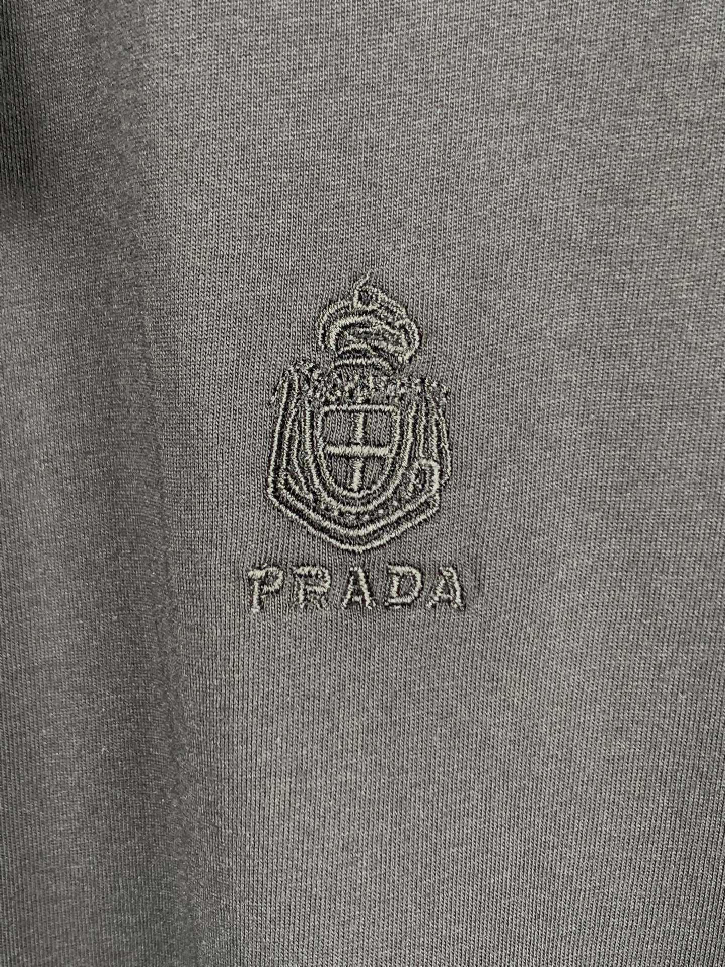 Prada T-shirt logo crest and PRADA text on dark fabric