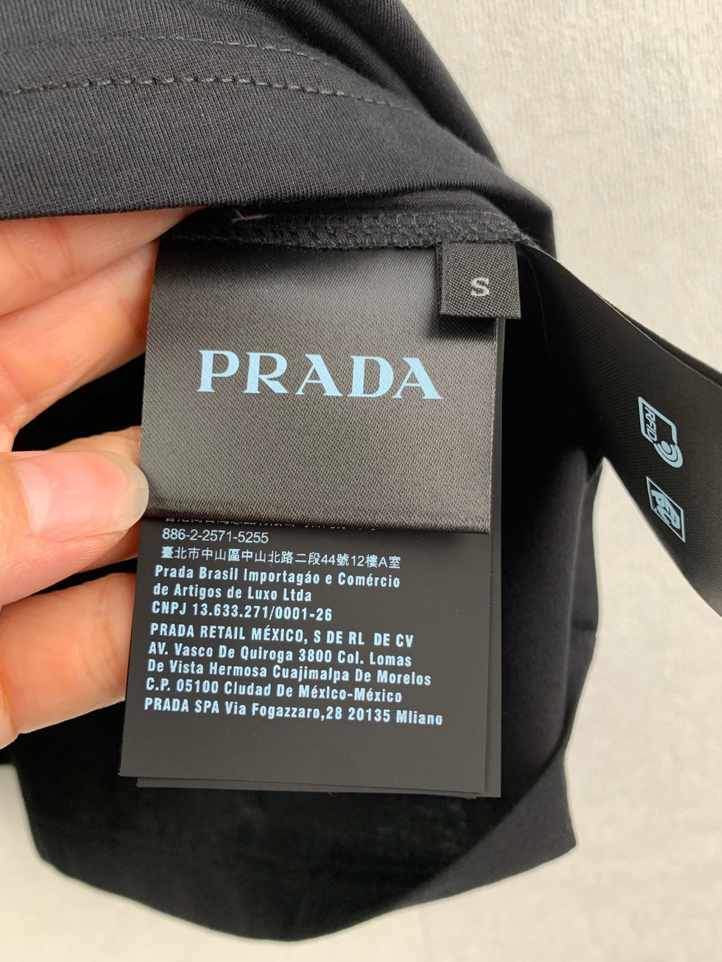 Prada neck label and size tag on dark T-shirt