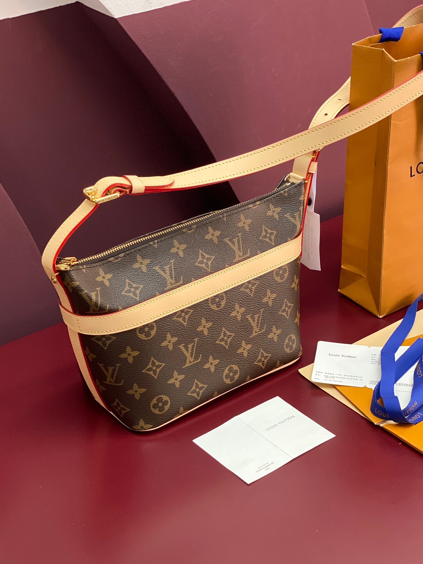 Louis Vuitton monogram crossbody bag with beige strap and gold-tone zip pull