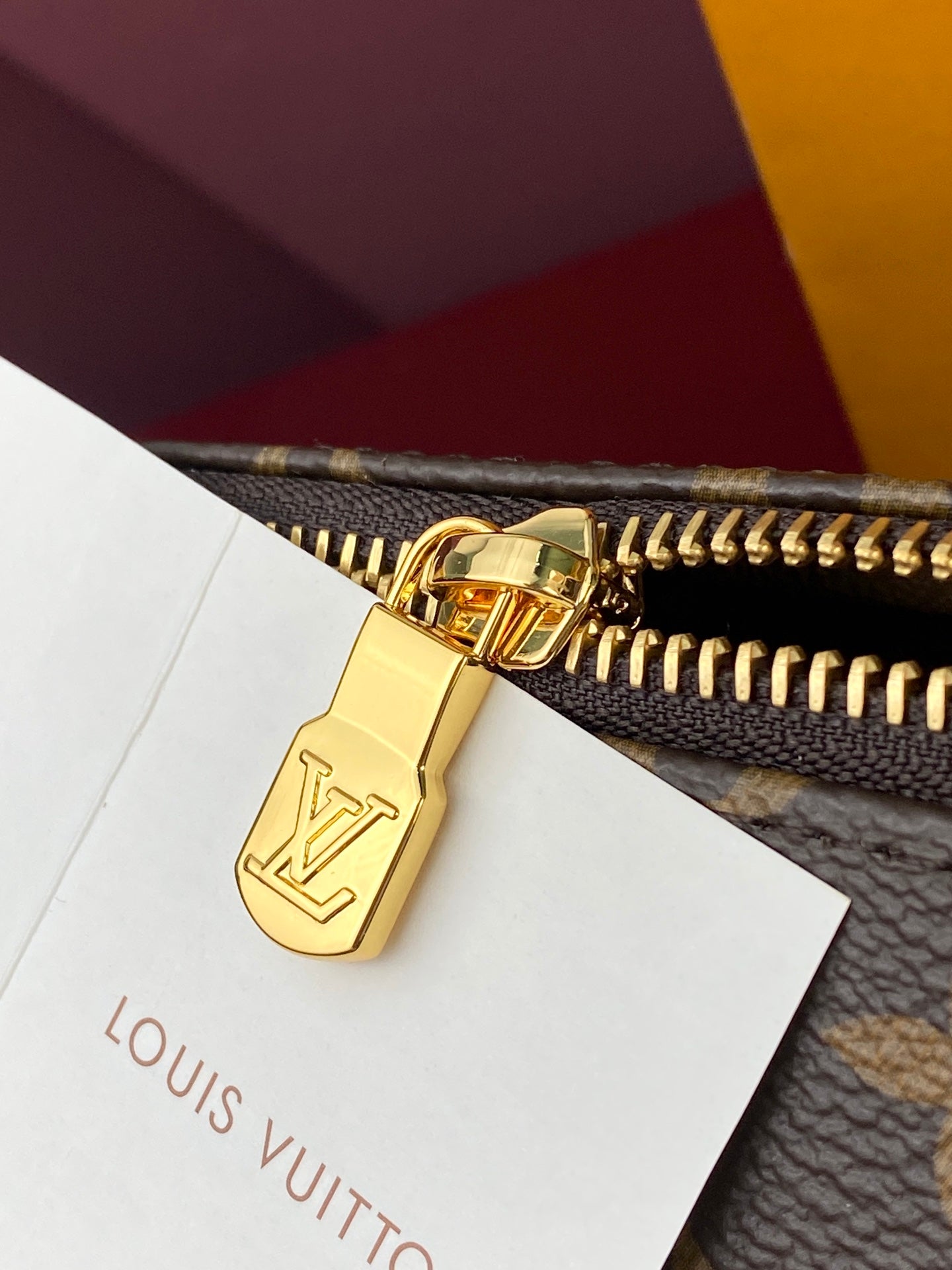 Louis Vuitton monogram bag zip with gold-tone lock and zipper pull