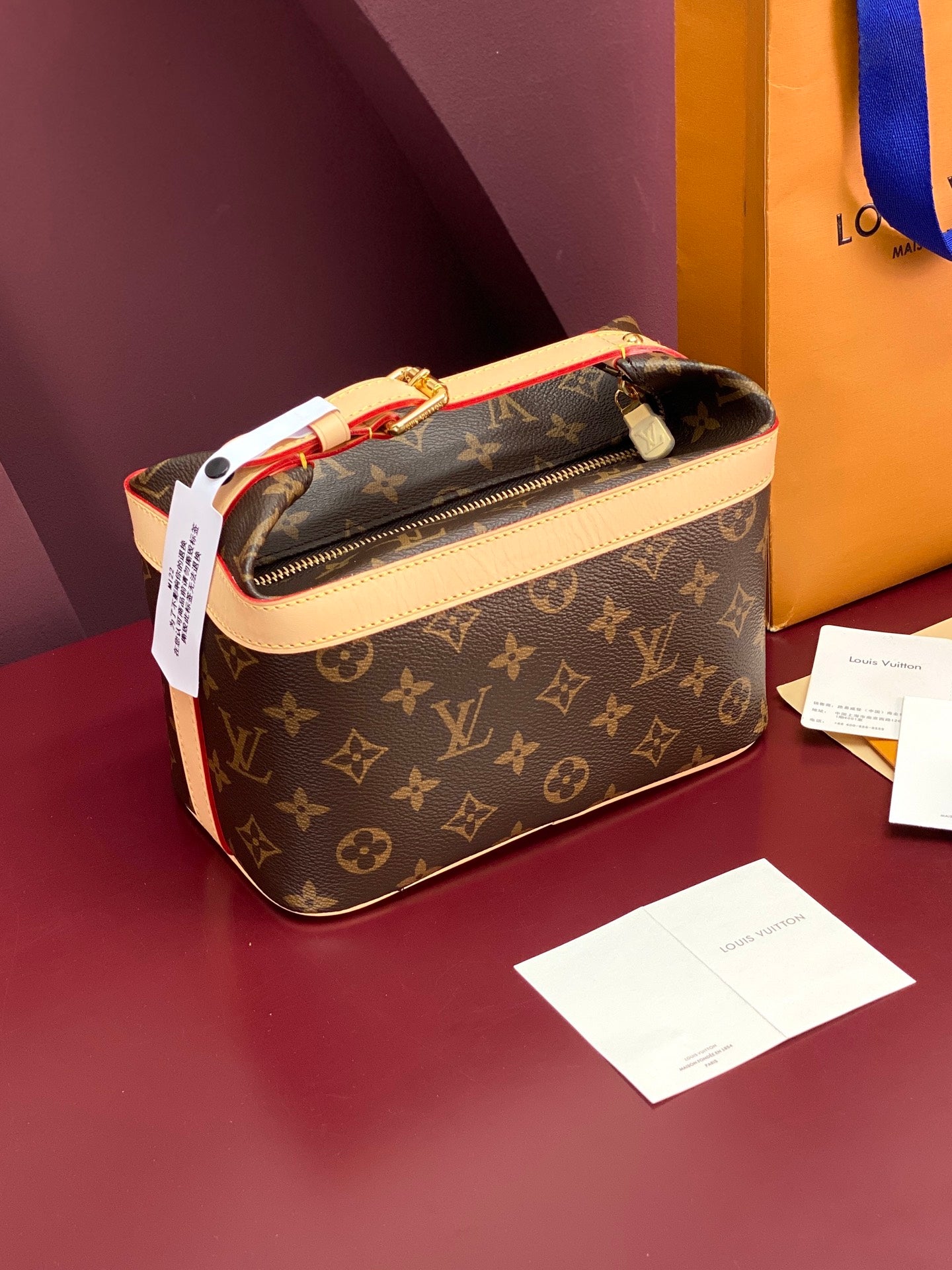 Louis Vuitton monogram bag in brown with cream trim, zip-top view