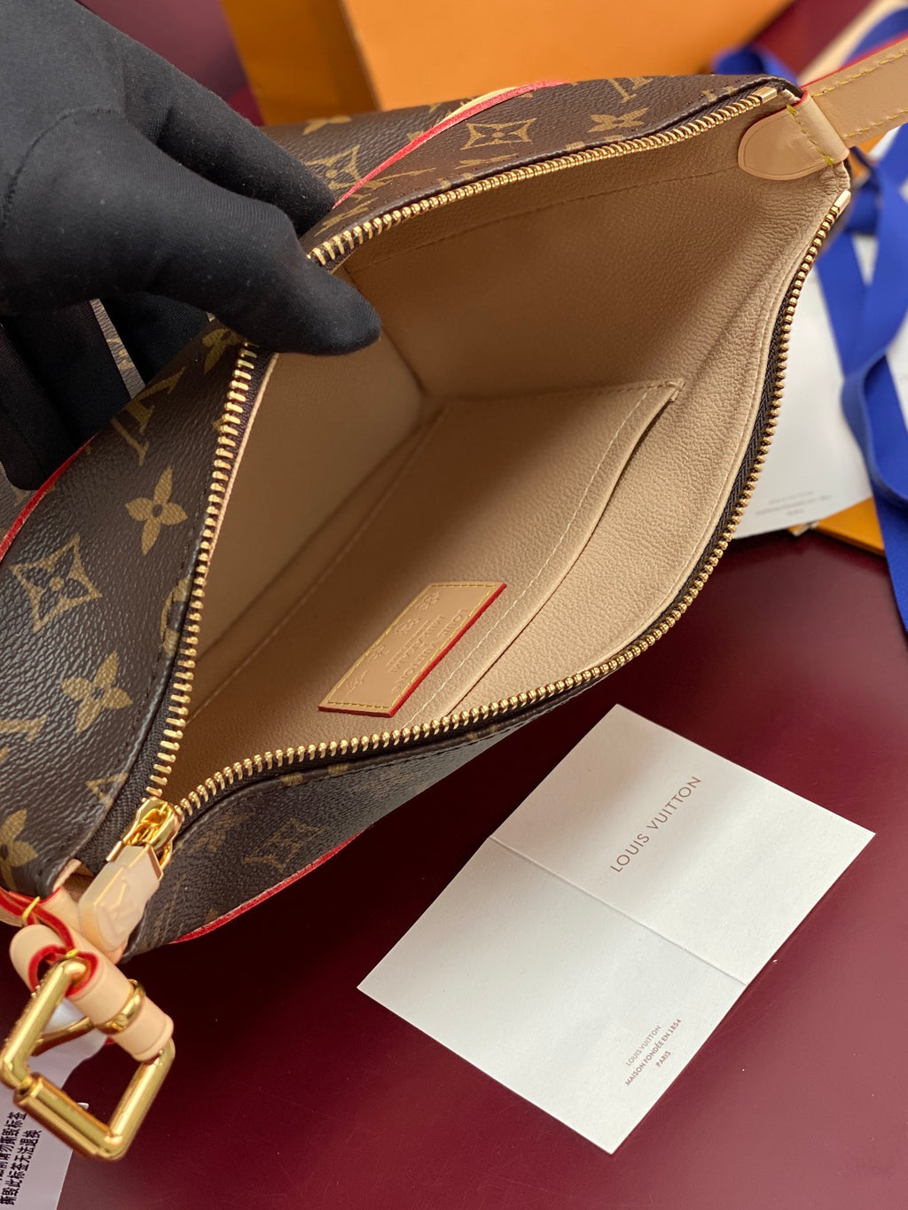 Louis Vuitton monogram bag open to beige interior lining with zip and pocket
