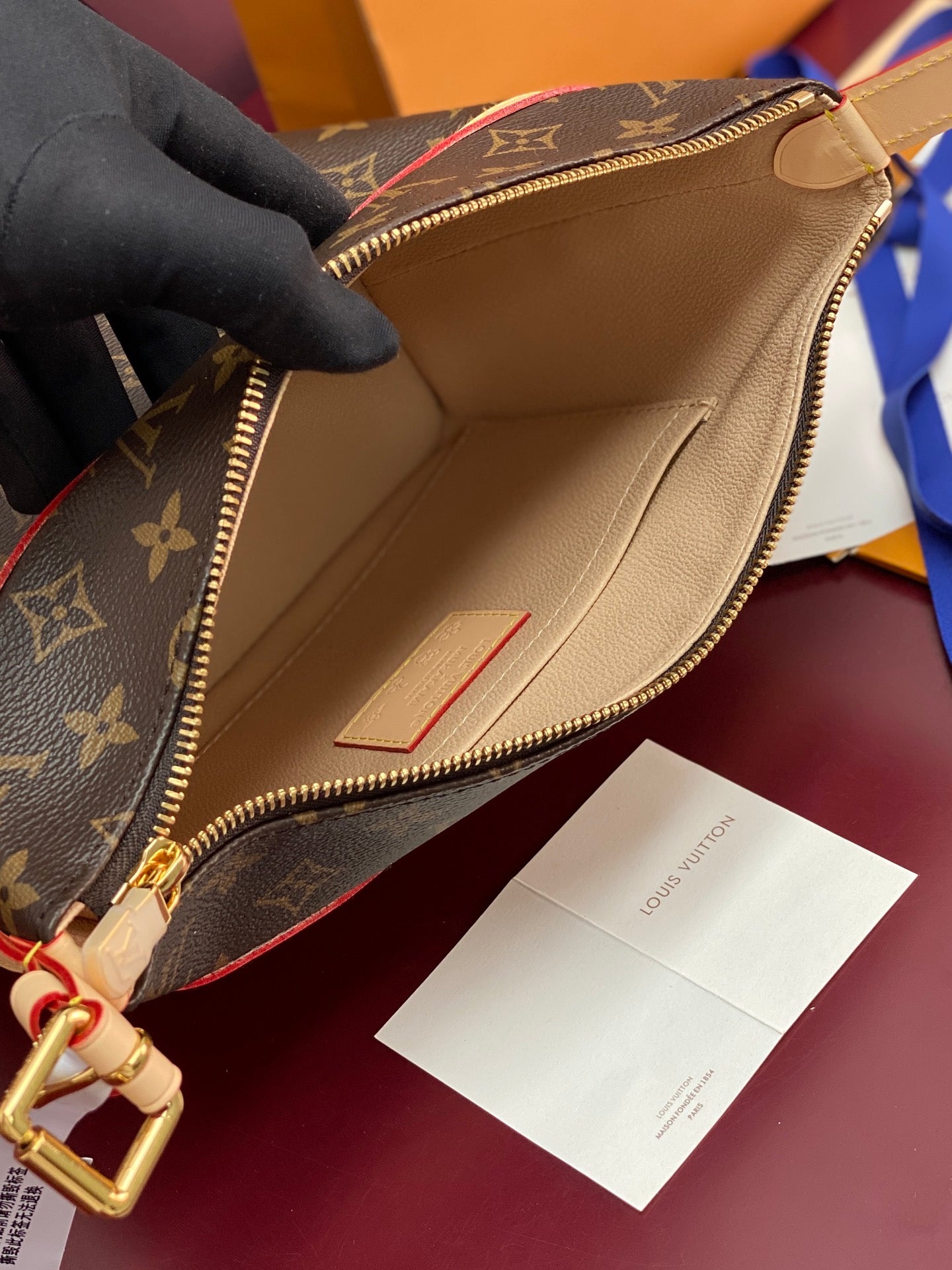 Louis Vuitton monogram bag open to beige interior lining with zip and pocket