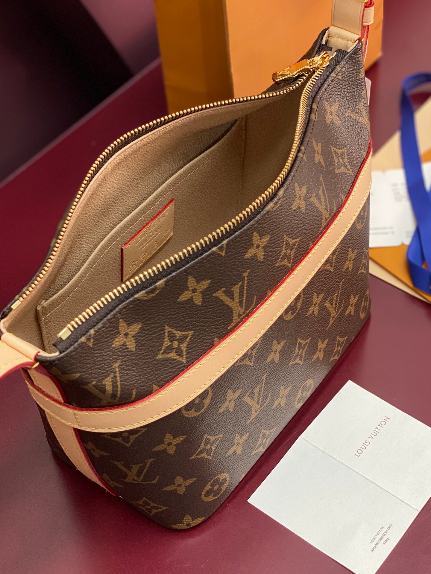 Louis Vuitton monogram bag interior with beige lining and gold zip closure