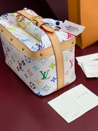 Louis Vuitton mini handbag with multicolor monogram print, tan straps and gold eyelets