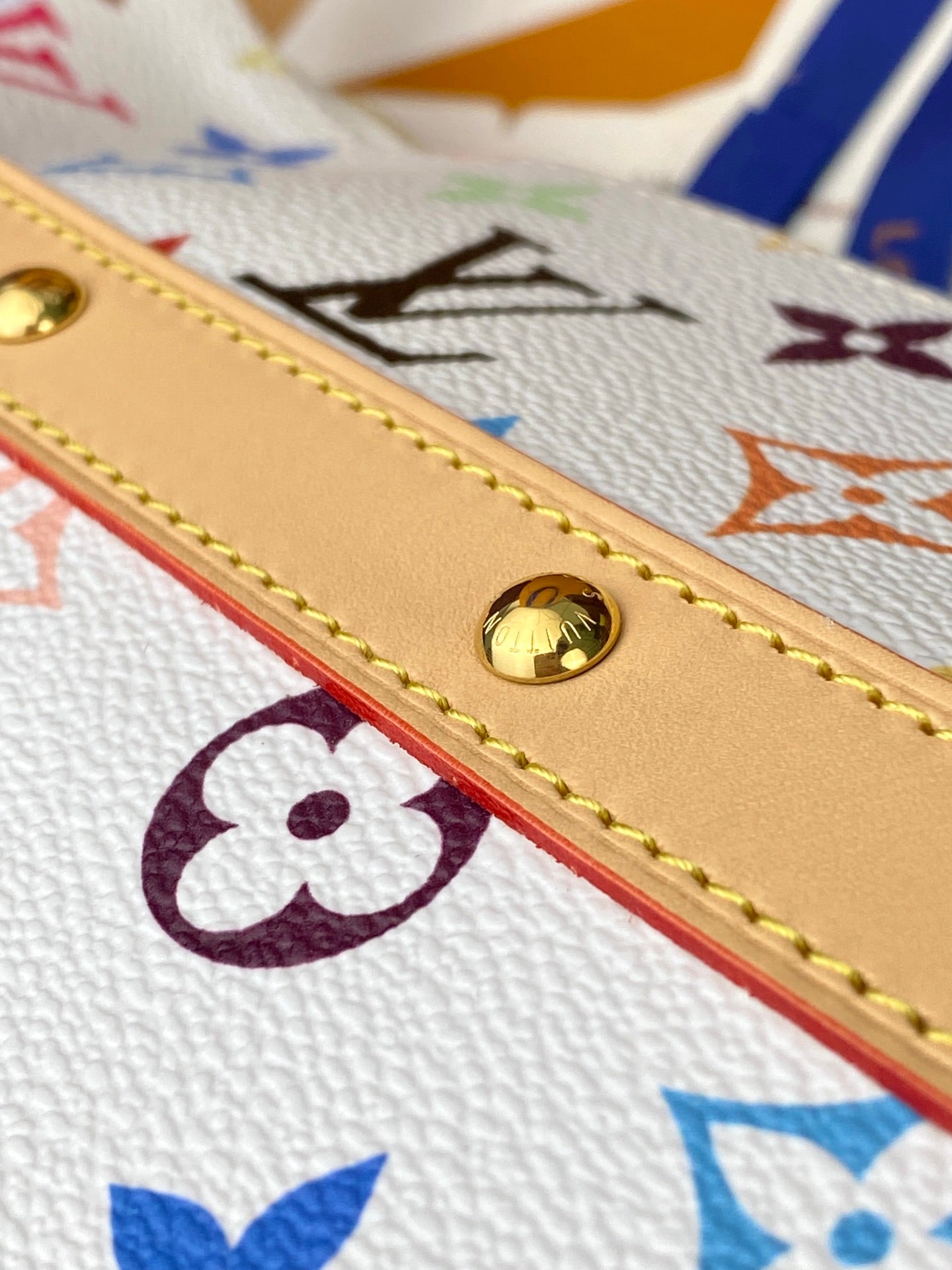 Louis Vuitton handbag strap close-up with gold snap and multicolor monogram print