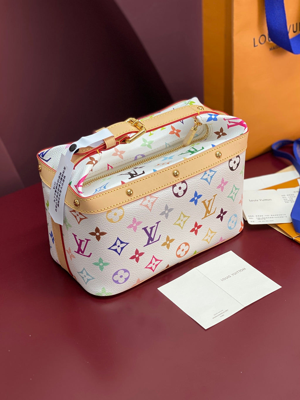 Louis Vuitton mini handbag with multicolor monogram print, top handle and gold hardware