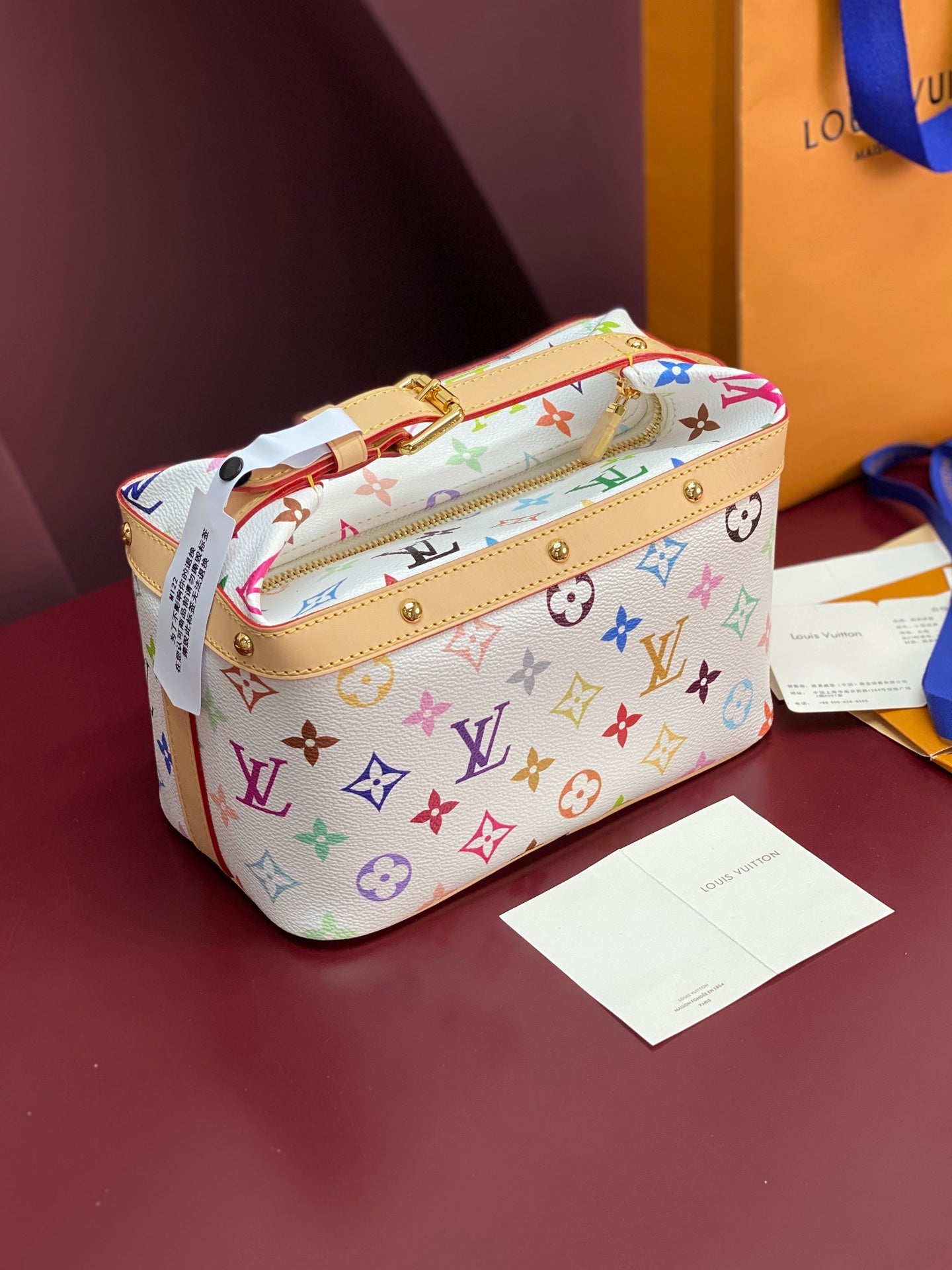Louis Vuitton mini handbag with multicolor monogram print, top handle and gold hardware
