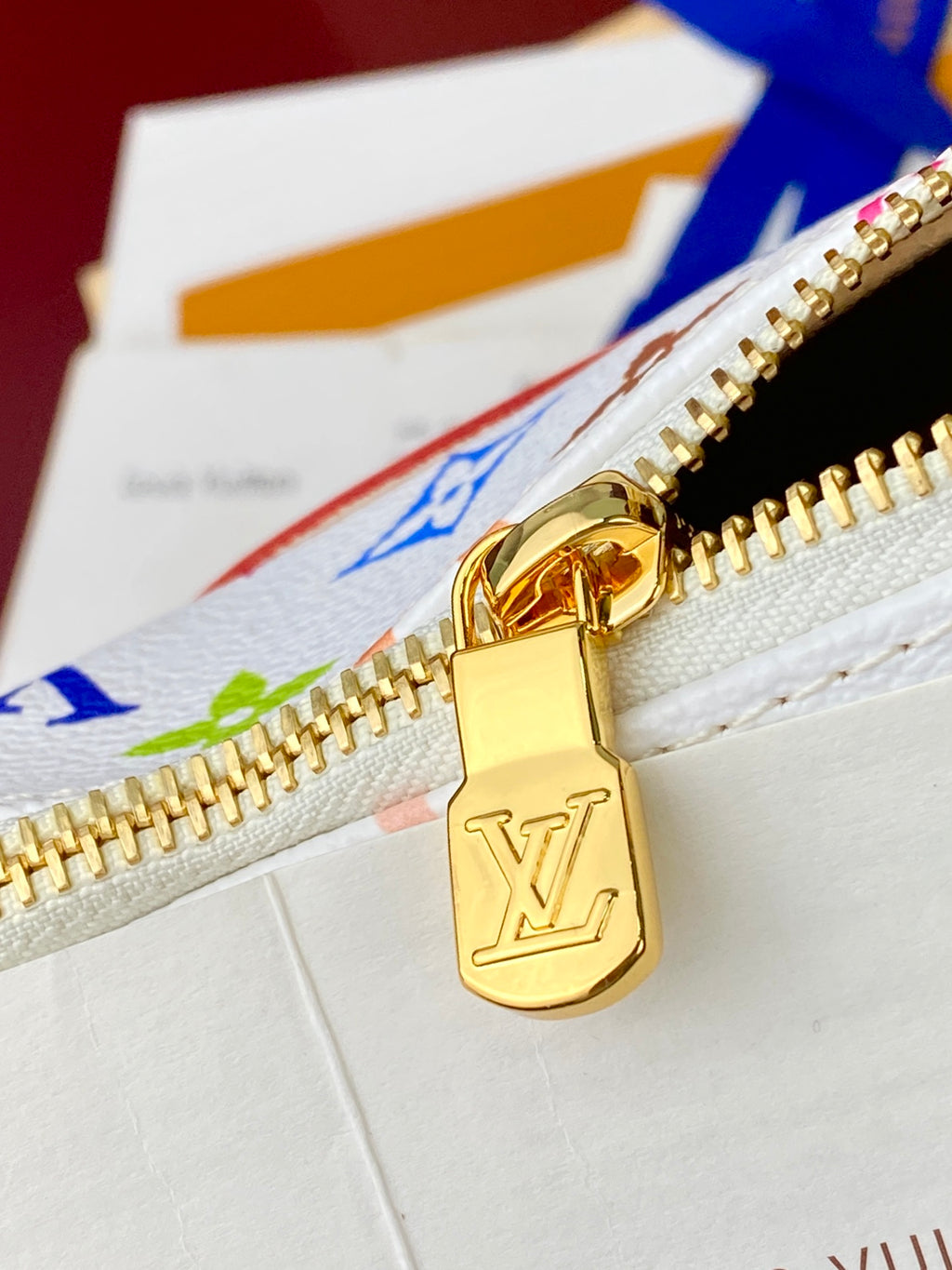 Louis Vuitton handbag zipper with gold LV lock pull on white multicolor canvas