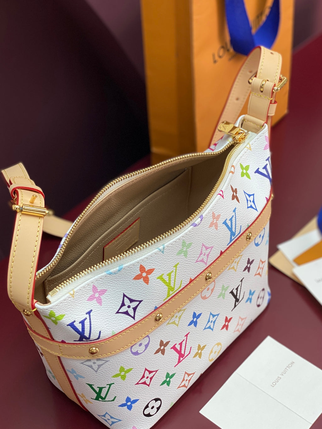 Louis Vuitton multicolor monogram crossbody bag with open zipper and tan interior