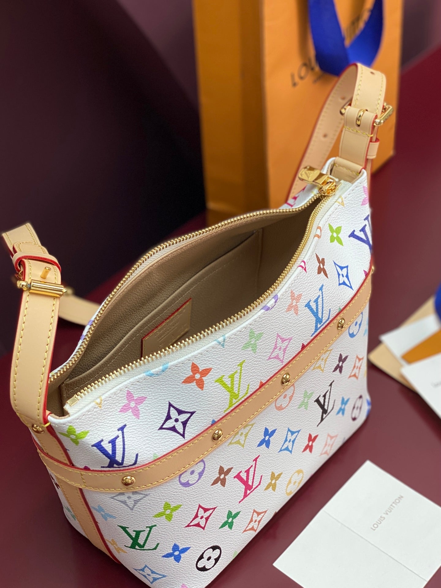Louis Vuitton multicolor monogram crossbody bag with open zipper and tan interior