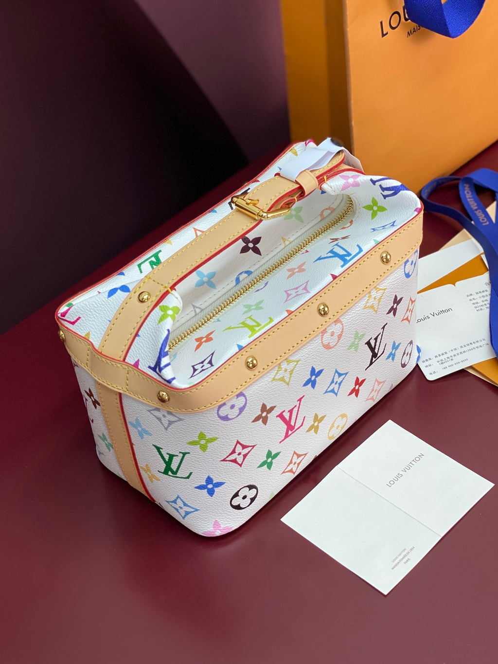 Louis Vuitton mini handbag with multicolor monogram print, tan trim and zipper top