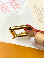 Louis Vuitton gold clasp with red and tan leather strap on bag