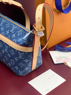 Louis Vuitton blue monogram bag with tan strap and gold buckle hardware detail