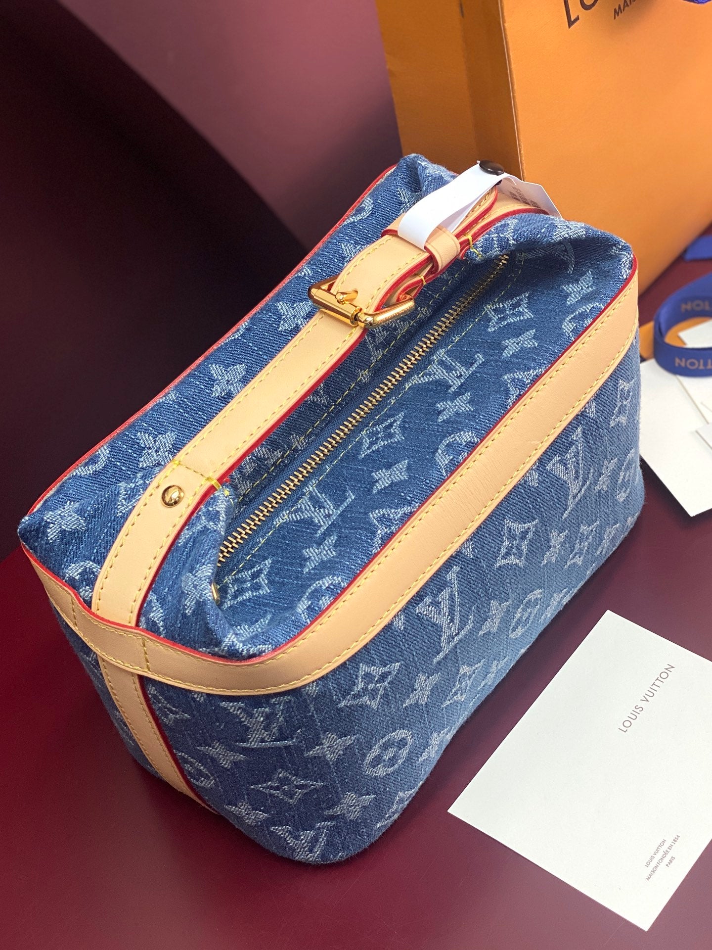 Louis Vuitton blue monogram bag with tan leather shoulder strap and gold zipper
