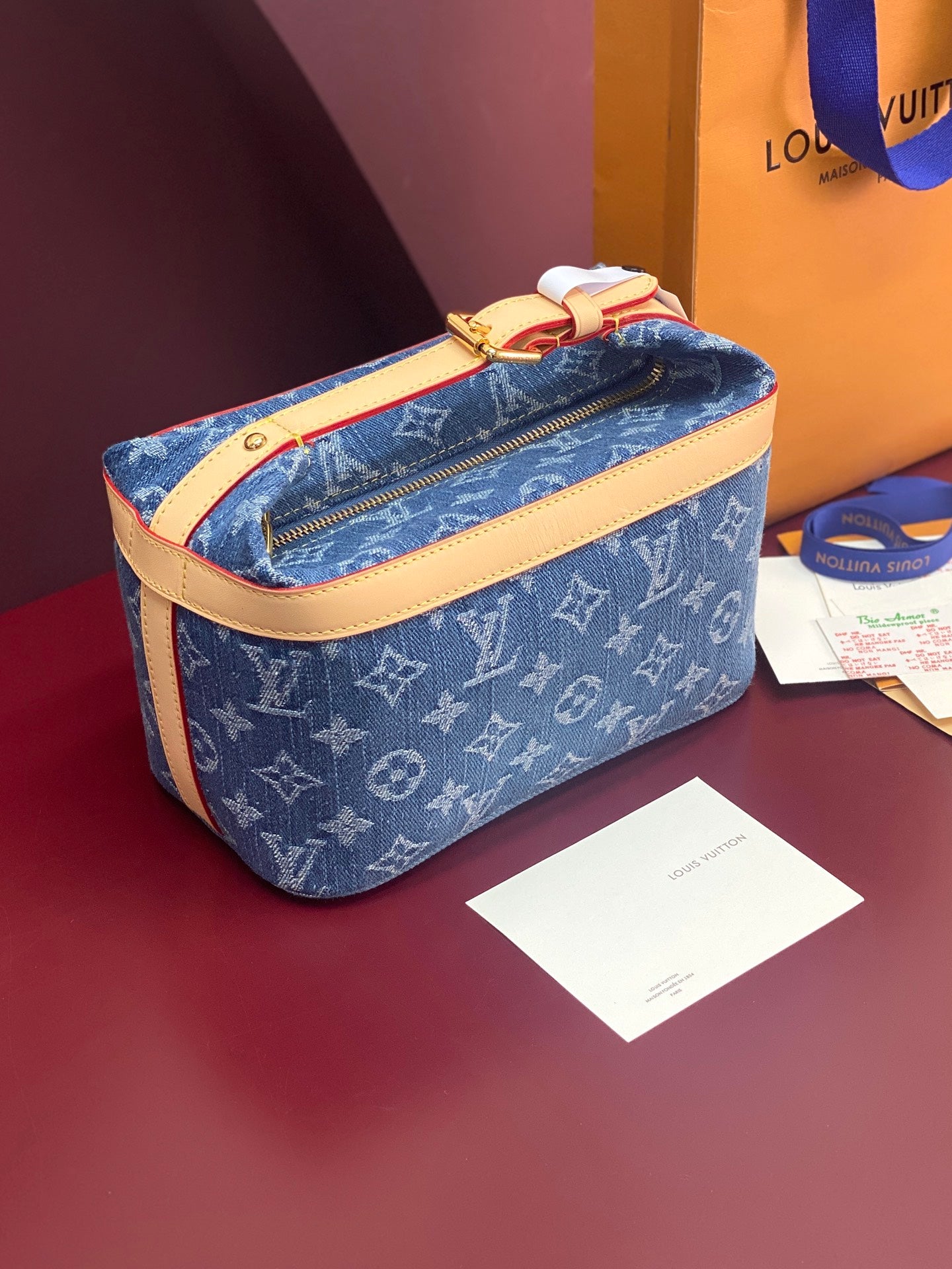 Louis Vuitton blue monogram bag with tan leather strap and gold top zip closure