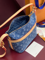 Louis Vuitton blue monogram bag with open zipper, tan strap, and gold zipper pull