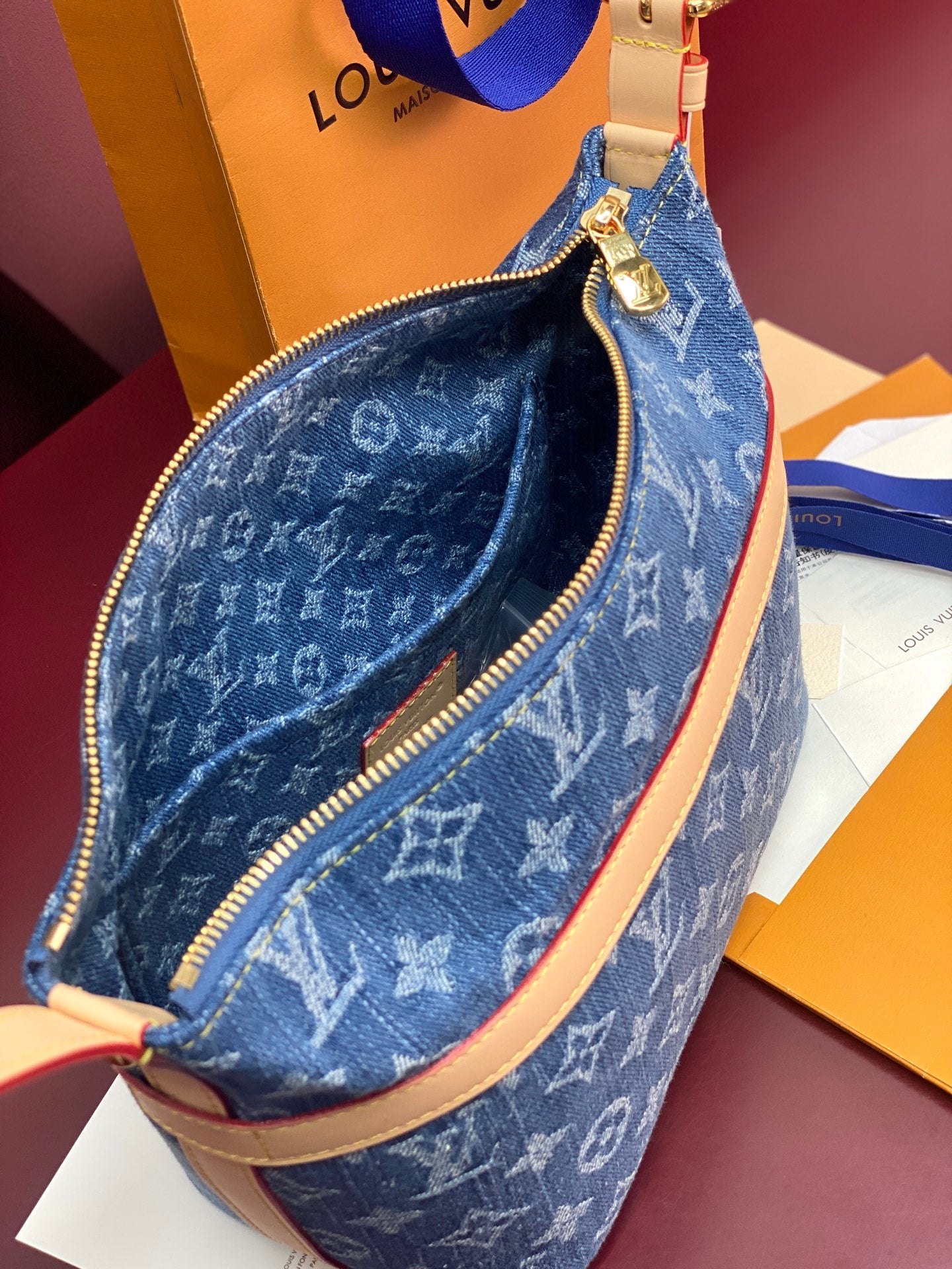 Louis Vuitton blue monogram mini bag with zipper opening and tan leather edging