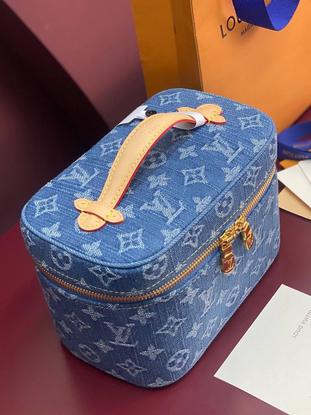 Louis Vuitton blue monogram vanity bag with tan handle and gold zipper trim